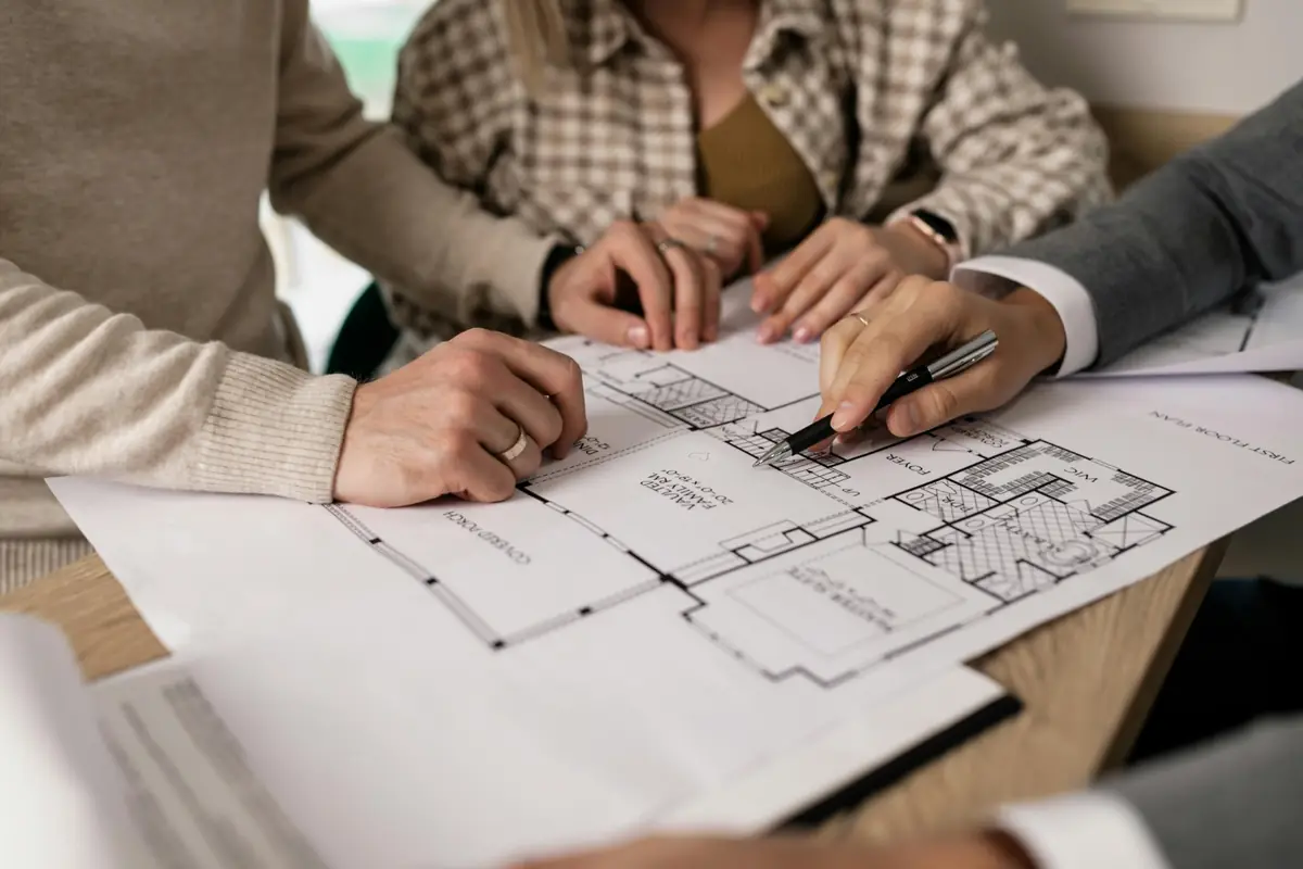 Architect team reviewing house blueprints at the table.